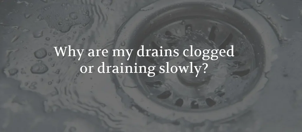 Close-up of a sink drain with slow-moving water, representing common clogged drain and slow drainage problems in homes