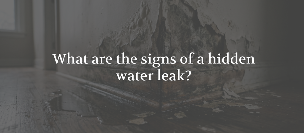 Water-damaged wall and flooring with peeling paint and dark moisture stains, overlaid with the text “What are the signs of a hidden water leak?”