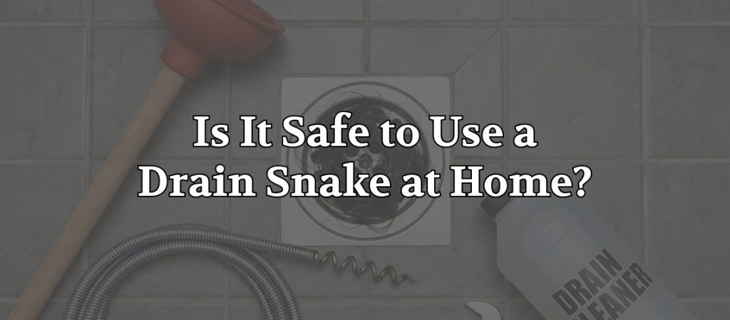 Drain cleaning tools, including a plunger, drain snake, and drain cleaner bottle, arranged around a bathroom floor drain, with the headline “Is It Safe to Use a Drain Snake at Home?” overlaid on the image.
