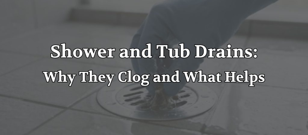 Close-up of a person cleaning a shower drain on a tiled bathroom floor, with the headline “Shower and Tub Drains: Why They Clog and What Helps” overlaid on the image.